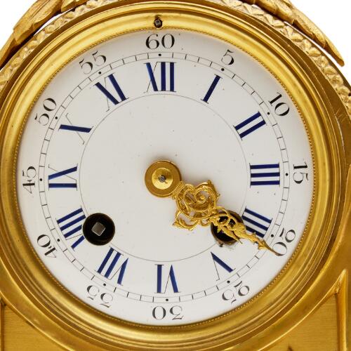 A French Louis XVI style mantel clock of gilded bronze with white