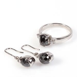 Diamantsmykkesæt bestående af ring og ørestikker, alle prydet med oval facetsleben sort diamant og facetslebne hvide sten. Str. 57. 2012. 3