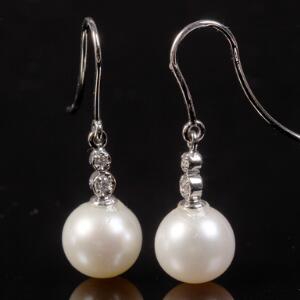 Et par perle- og diamantørestikker af 14 kt. hvidguld hver prydet med Southsea perle og brilliantslebne diamanter. Perlediam. ca. 0,5 cm L. ca. 2,5 cm.