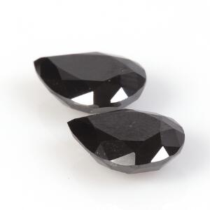 To uindfattede sorte diamante, begge dråbeformede og facetslebne, på i alt ca. 6.89 ct. Certifikat medfølger. 2012.