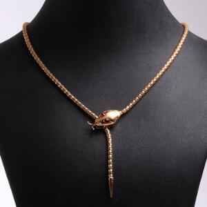 Smykkesæt af 18 kt. guld bestående af kæde og øreskrue i form af slange prydet med røde sten. L. 51 og 6 cm. Vægt i alt 20,5 gr. 2