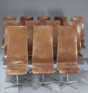 Arne Jacobsen Oxford. Sæt på 12 højryggede stole opsat på fempasfod af aluminium. Sæde og ryg betrukket med farvet brunt skind. 12