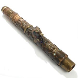 Større orientalsk opiumspibe af bambus og lak, rigt prydet med orientalske mønter, glasflusser og messing. 20. årh.s første halvdel. L. 48.