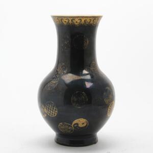 Kinesisk balusterformet vase af porcelæn, dekoreret med sort glasur og gulddekoration. Mærket Qianlong, 19. årh. H. 19 cm.