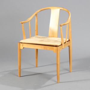 Hans J. Wegner Kina-stol. Armstol af kirsebærtræ, løs hynde i sæde med betræk af lyst, dybthæftet skind. Udført hos Fritz Hansen.