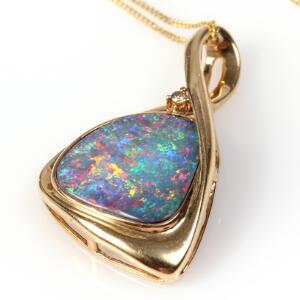Opalvedhæng af 14 kt. guld prydet med cabochonslebet opaltriplet. L. ca. 2,5 cm. Kæde af 14 kt. guld medfølger. L. ca. 40 cm.