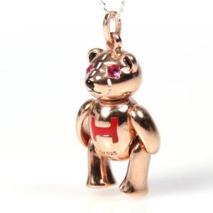 Rubinvedhæng af forgyldt sterling sølv i form af bamse prydet med facetslebne rubiner og dekoreret med emalje. L. ca. 2 cm. Kæde af sterling sølv medfølger.