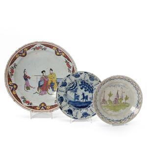 Tre tallerkner af fajance, dekorerede i henholdsvis farver og blå med kineserier, huse og dyr. 19. årh. Diam. 23-35 cm. 3