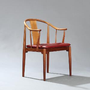 Hans J. Wegner Kinastol. Armstol af mahogni, løs hynde i sæde med betræk af rødt, dybthæftet skind. Model 4283. Udført hos Fritz Hansen.