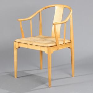 Hans J. Wegner Kina-stol. Armstol af kirsebærtræ, løs hynde i sæde med betræk af lyst, dybthæftet skind. Udført hos Fritz Hansen.