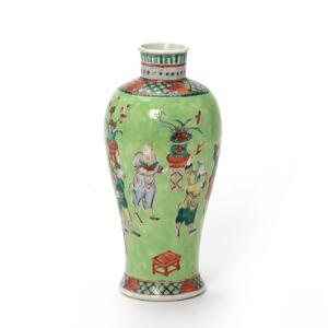 Vase af porcelæn i famille verte stil, dekoreret i farver med figurer og dyrebare genstande. Kina, 20. årh. H. 25 cm.