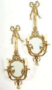 Et par lampetspejle af bronze, hver med to lysarme, støbt med sløjfer, pilekogger og bladværk. Louis XVI form. 20.-21. årh. H. 76. B. 30. 2