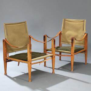 Kaare Klint Safaristolen. Et par hvilestole af ask. Sæde og ryg af lys kanvas, løse dybthæftede sædehynder betrukket med grøn kanvas. 2