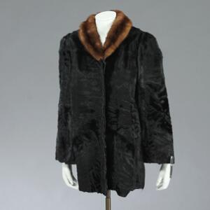 Sort swakara pelsfrakke med brun minkkrave. Str. 42. L. ca. 80 cm. B. ca. 45 cm. Ydre ærmelængde. ca. 65 cm. Indre ærmelængde. ca. 42 cm.