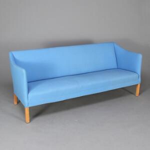 Ejner Larsen Statssofa. Tre-pers. sofa med ben af eg. Sæde, sider samt ryg betrukket med lys blå uld. L. 200.