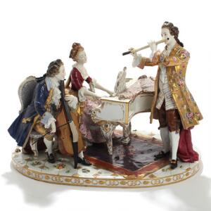 Musicerende trio. Figurgruppe af porcelæn dekoreret i farver og guld. Mærket. Tyskland. 20. årh. H. 40.