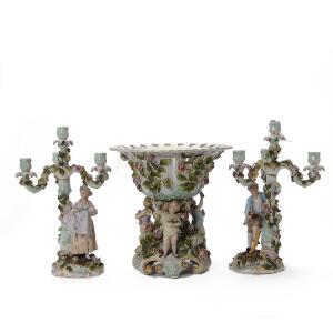 Garniture af porcelæn bestående af opsats samt to kandelabra dekoreret i farver med figurer og pousserede blomster. Tyskland, 20. årh. H. 3036 cm. 3
