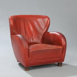 Flemming Lassen, tilskrevet Lænestol med ben af mørkpoleret eg. Sæde, sider samt ryg betrukket med rødt, farvet skind.