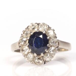 Safir- og diamantring af 14 kt. hvidguld prydet med facetslebet safir omkranset af brillantslebne diamanter med ældre slibning. Str. 55.