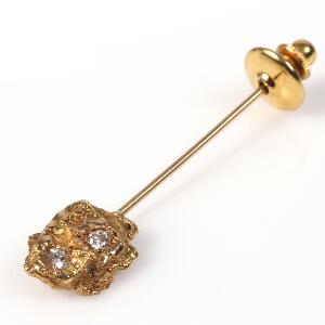 Slipsenål af 18 kt. satineret guld prydet med to brillantslebne diamanter. Lås af gulddouble. L. 5,5 cm. Vægt uden lås ca. 4,5 gr.