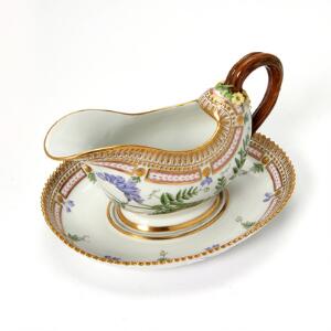 Flora Danica sauceskål på fast fod af porcelæn, dekoreret i farver og guld. 3556. Royal Copenhagen. H. 14 cm L. 22 cm.