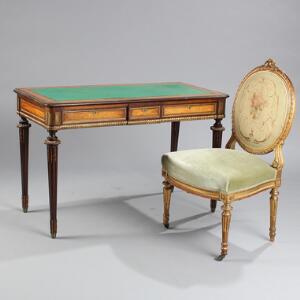 Fritstående skrivebord af mahogni med indlægninger af lyst træ samt stol af udskåret og forgyldt træ. Louis XVI form. 19.-20. årh. 2