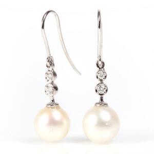 Et par perle- og diamantørestikker af 14 kt. hvidguld hver prydet med ferskvands kulturperle og brillantslebne diamanter. Perlediam. ca. 8,0 mm. L. ca. 3 cm.