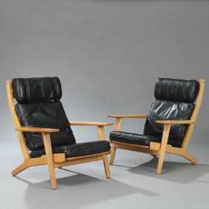 Hans J. Wegner GE-290. Et par lænestole med stel af eg. Løse hynder betrukket med sort skind. Udført hos Getama. 2
