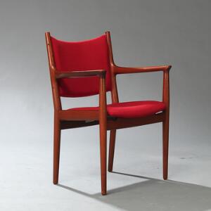 Hans J. Wegner JH 513. Armstol med stel af teak. Sæde samt ryg betrukket med rød uld. Udført hos Johannes Hansen.