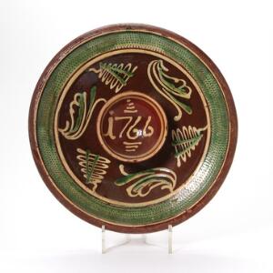 Grødfad af keramik dekoreret i farver og dateret 1766. Diam. 34 cm.