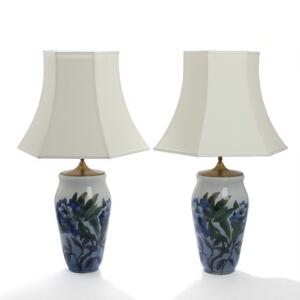 Et par bordlamper af porcelæn, Kgl. P., dekorerede med blå blomster, sekskantede skærme. Sign. i bunden UF 845, 1216. H. inkl. skærme 75. 2