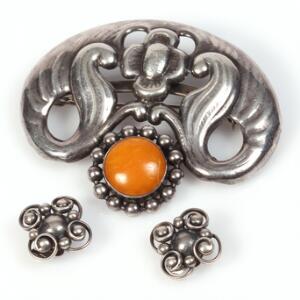 Skønvirke smykkesæt af sølv bestående af broche prydet med cabochonslebet rav samt et par øreclips. L. broche ca. 6 cm. L. øreclips 1,7 cm. 3