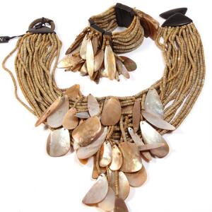 Gerda Lynggaard smykkesæt bestående af halsmykke og armlænke prydet med vedhæng af kunstmateriale og perlemor med lås af træ. L. ca. 18 og 48 cm.