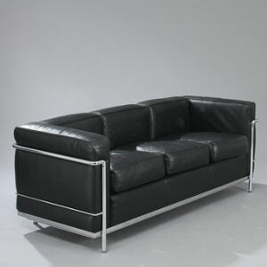 Le Corbusier LC-2. Fritstående tre-personers sofa med stel af forkromet stål, sæde, ryg, løse hynder og armlæn betrukket med sort skind. L. 180.