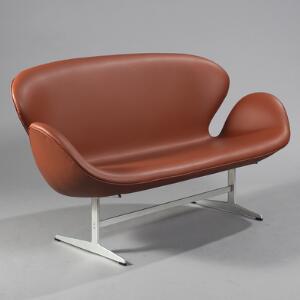 Arne Jacobsen Svanesofa. Fritstående to-personers sofa med stel af aluminium, sæde, ryg og sider med tan-farvet skind. L. 145.