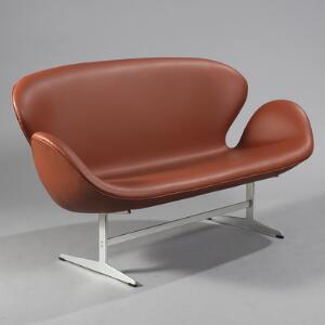 Arne Jacobsen Svanesofa. Fritstående to-personers sofa med stel af aluminium, sæde, ryg og sider med tan-farvet skind. L. 145.