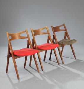 Hans J. Wegner Savbukkestolen. Et sæt på tre stole af eg, sæder betrukket med rødt og brunt stof. Model CH 29. 3