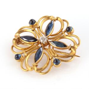 Safir-og diamantbroche af 18 kt. guld prydet med facet-og cabochonslebne safirer og brillantslebet diamant med ældre slibning. L. 3 cm. Original æske medfølger.