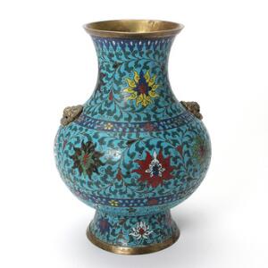 Cloisonne vase dekoreret i farver, balusterformet med blomster og bladslyng, hanke i form af Fo-hundehoveder. 19. årh eller senere. H. 36.