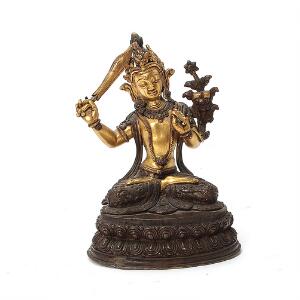 Manjushri af delvis forgyldt, patineret og bemalet bronze, prydet med farvede stene. Nepal, 20. årh. H. 16,5 cm.