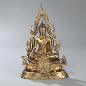 Buddha Shakyamuni af forgyldt bronze, siddende på lotustrone med to figurer samt flamme mandorla. Thailand, 20. årh. H. 91 cm.