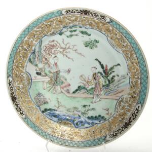 Kinesisk famille rose tallerken af porcelæn, dekoreret i farver og guld med kvinder i have. Yongzheng 1723-36. Diam. 23 cm.