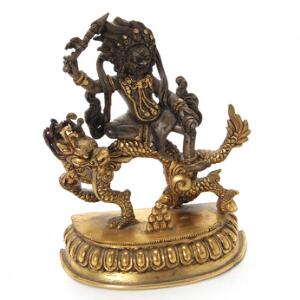 Vred guddom siddende på drage af patineret og delvist forgyldt bronze. Sino Tibet, 20. årh. H. 11,5 cm.