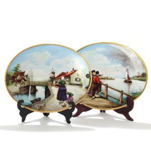 To hollandske ovale plaketter af porcelæn, dekorerede med personer ved kanaler i farver og guld. 19.-20. årh. H. 33,5. B. 41,5. 2