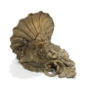 Vægprydelse af delvist forgyldt metal rigt støbt med putto, rocailler, kæmninger og musling. Ca. 1900. H. 44. 2