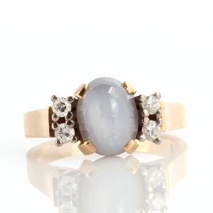 Safir- og diamantring 14 karat guld prydet med cabochonslebet stjernesafir flankeret af brillantslebne diamanter. Str. 51