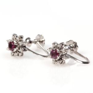 Et par rubin- og diamantøreskruer af 14 kt. hvidguld hver prydet med facetslebet rubin omkranset af brilliantslebne diamanter. L. ca. 2 cm. 2