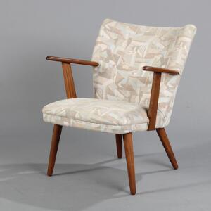Dansk design Armstol af teaktræ med lyst, mønsteret møbelstof, runde tilspidsede ben.