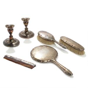 Toiletgarniture af sølv bestående af spejl, to børster og kam samt et par stager af sølv. Udfyldte. H. 11. 6