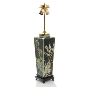 Kinesisk bordlampe af porcelæn, dekoreret i hvid, sort og grøn med blomster og greværk, stående på base af sortbejdset træ. 19. årh. H. 80.